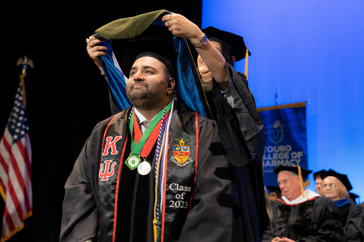 Kenneth Pawa is hooded during the Touro College of Pharmacy\'s commencement exercises.