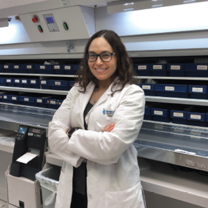 Image of Dr. Sybil Goday Peña standing and smiling in a pharmacy setting.