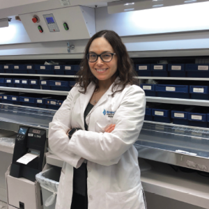 Image of Dr. Sybil Goday Pe&ntilde;a standing and smiling in a pharmacy setting.