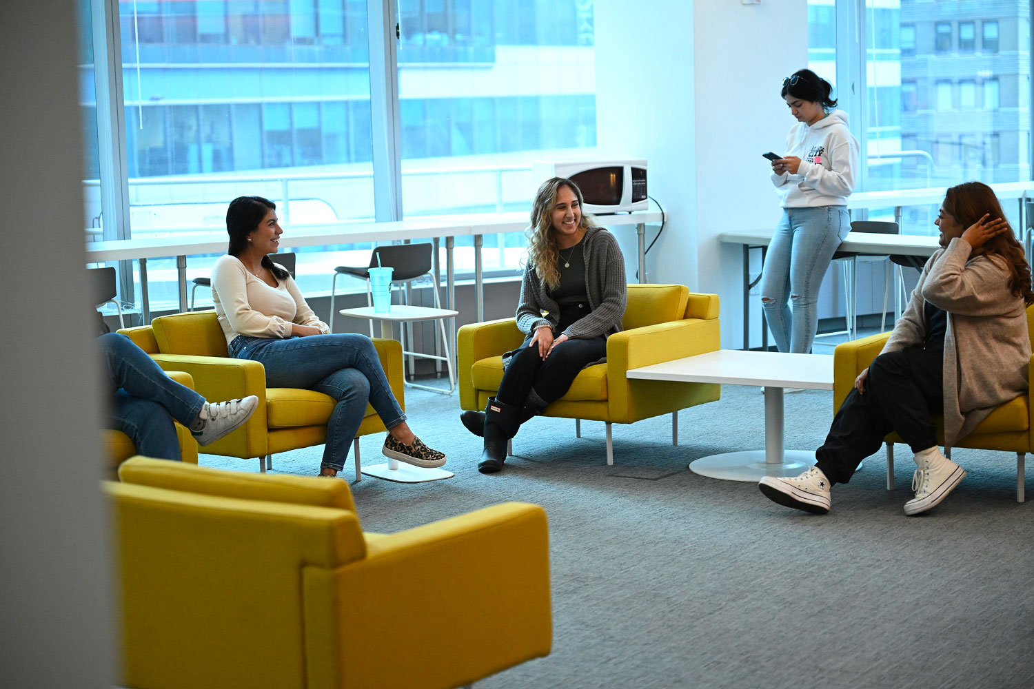 students chatting while sitting in seating area at 3 times square