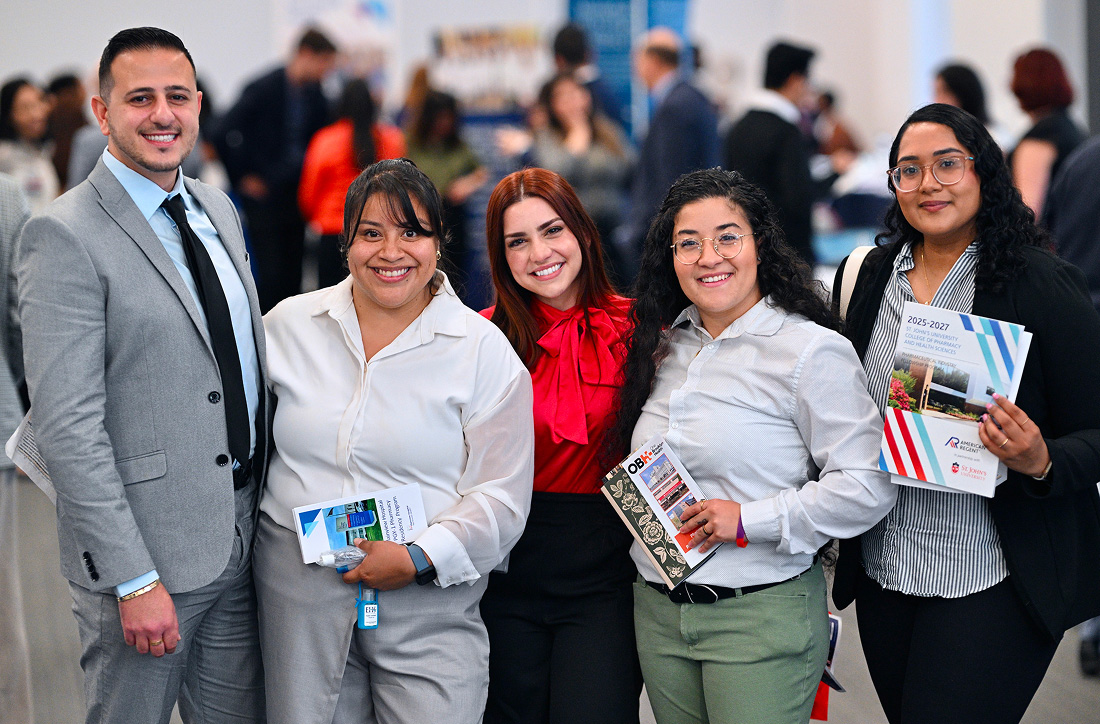Students smiling and holding pamphlets about fellowships