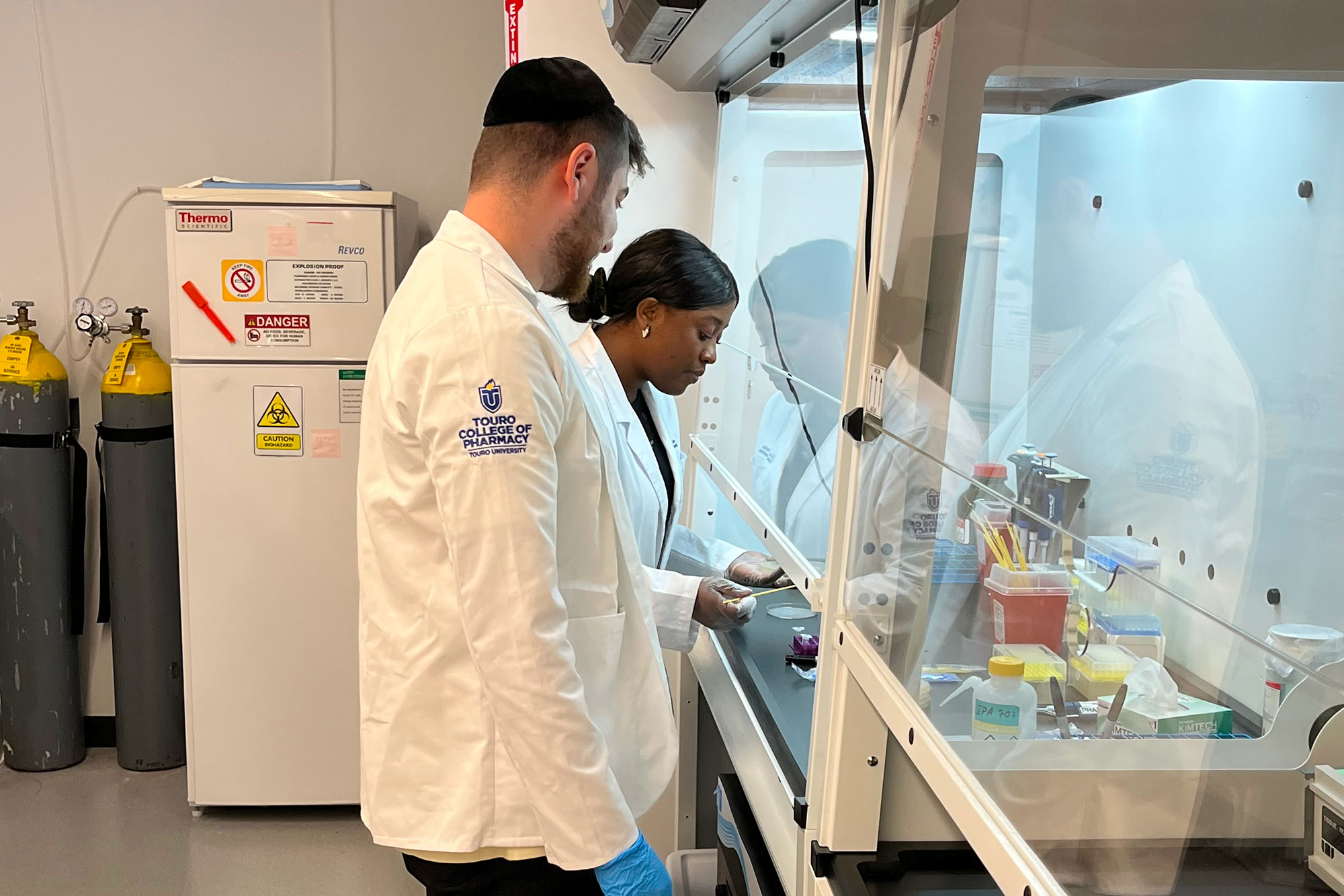 Two students conducting research together in lab