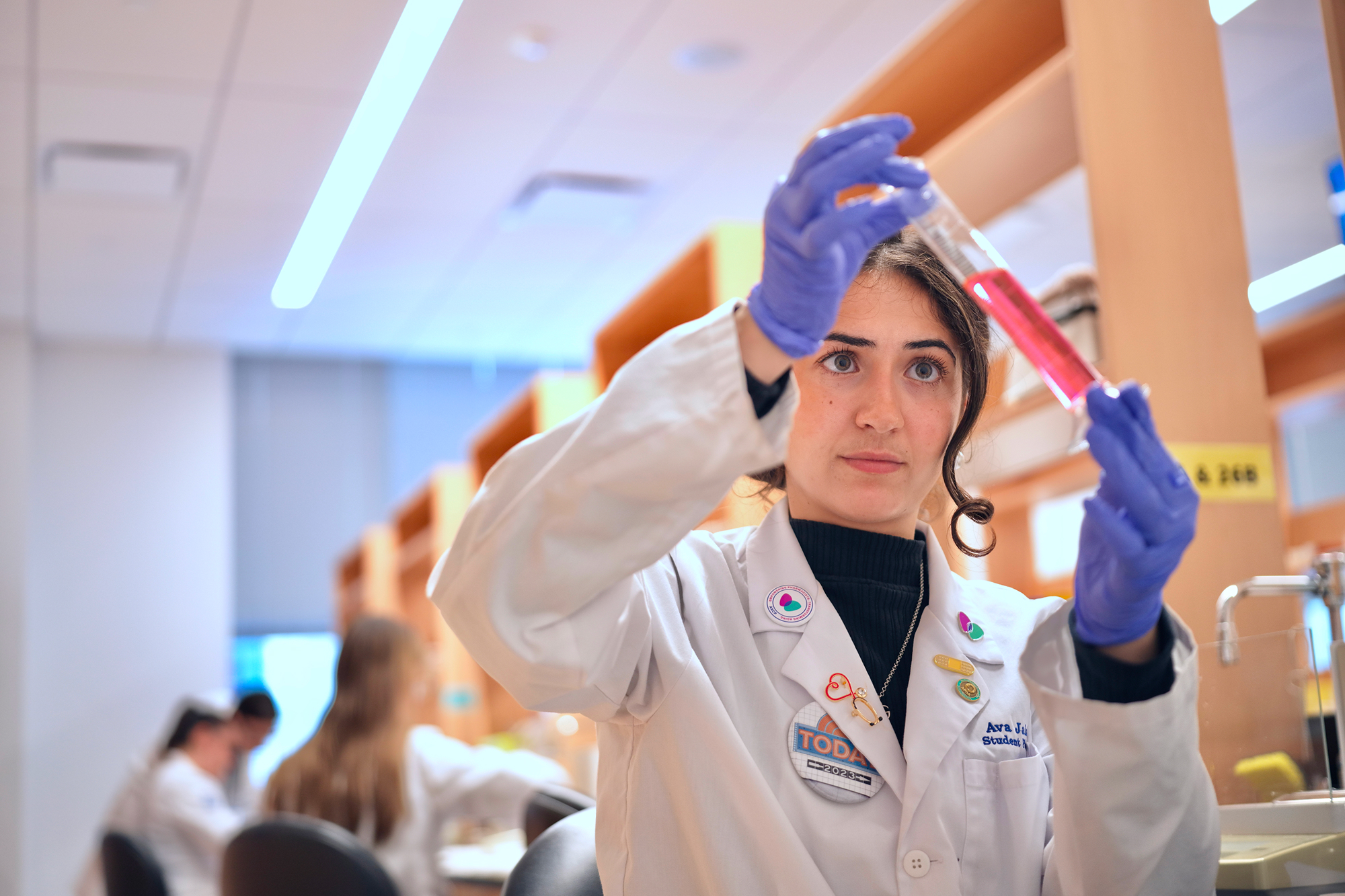 Female student looking at a chemical in a test tube