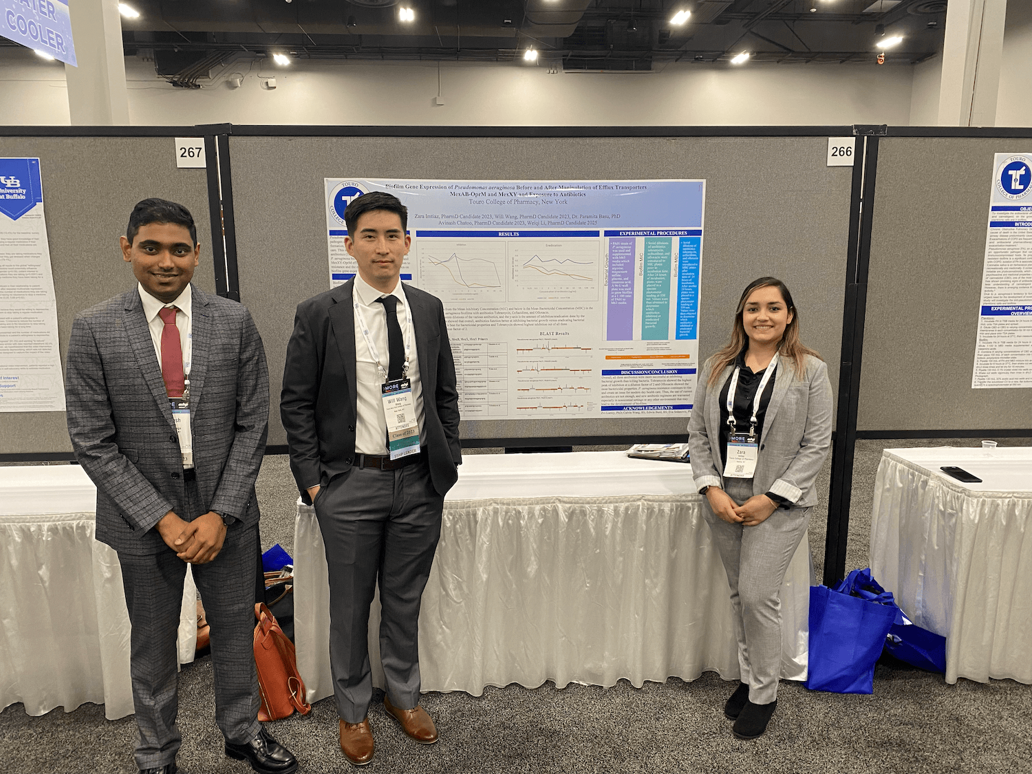 TCOP students Avinash Chatoo, Will Wang and Zara Imtiaz stand by their poster presentation at Mid-Year 2022.