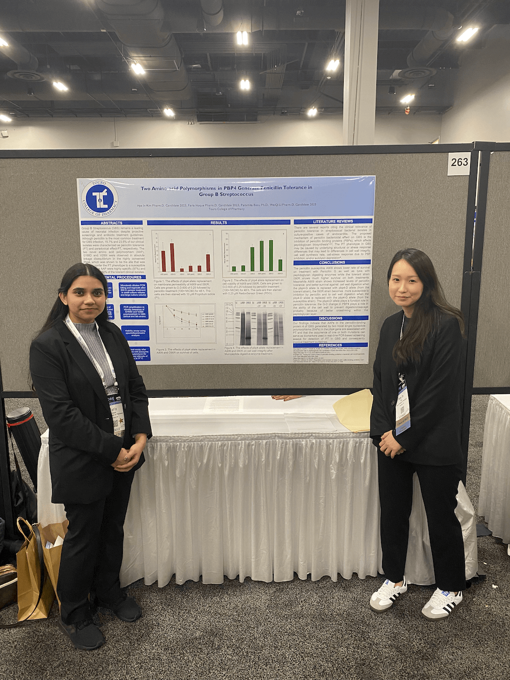 TCOP students stand before their poster presentation at Midyear 2022.