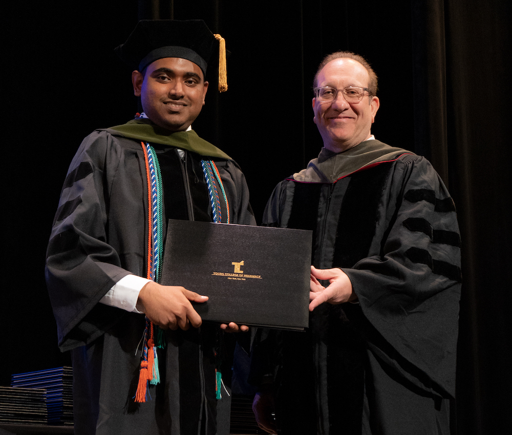 Avinash Chatoo receiving his diploma from TCOP Dean Henry Cohen. 