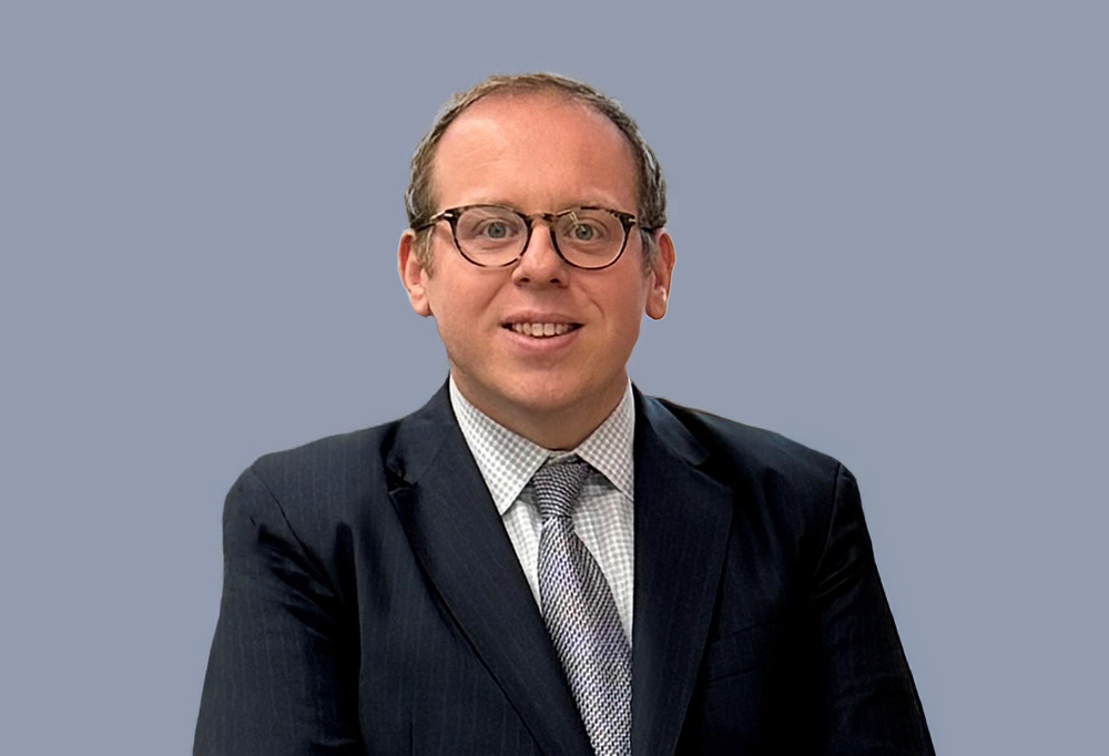photo of male researcher sitting down smiling at camera 