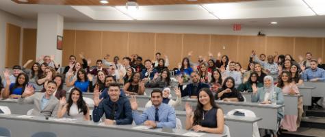 first-year pharmacy students waving hello in lecture hall just before their official cloaking