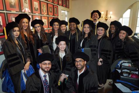 graduates smiling at camera wearing caps and gowns