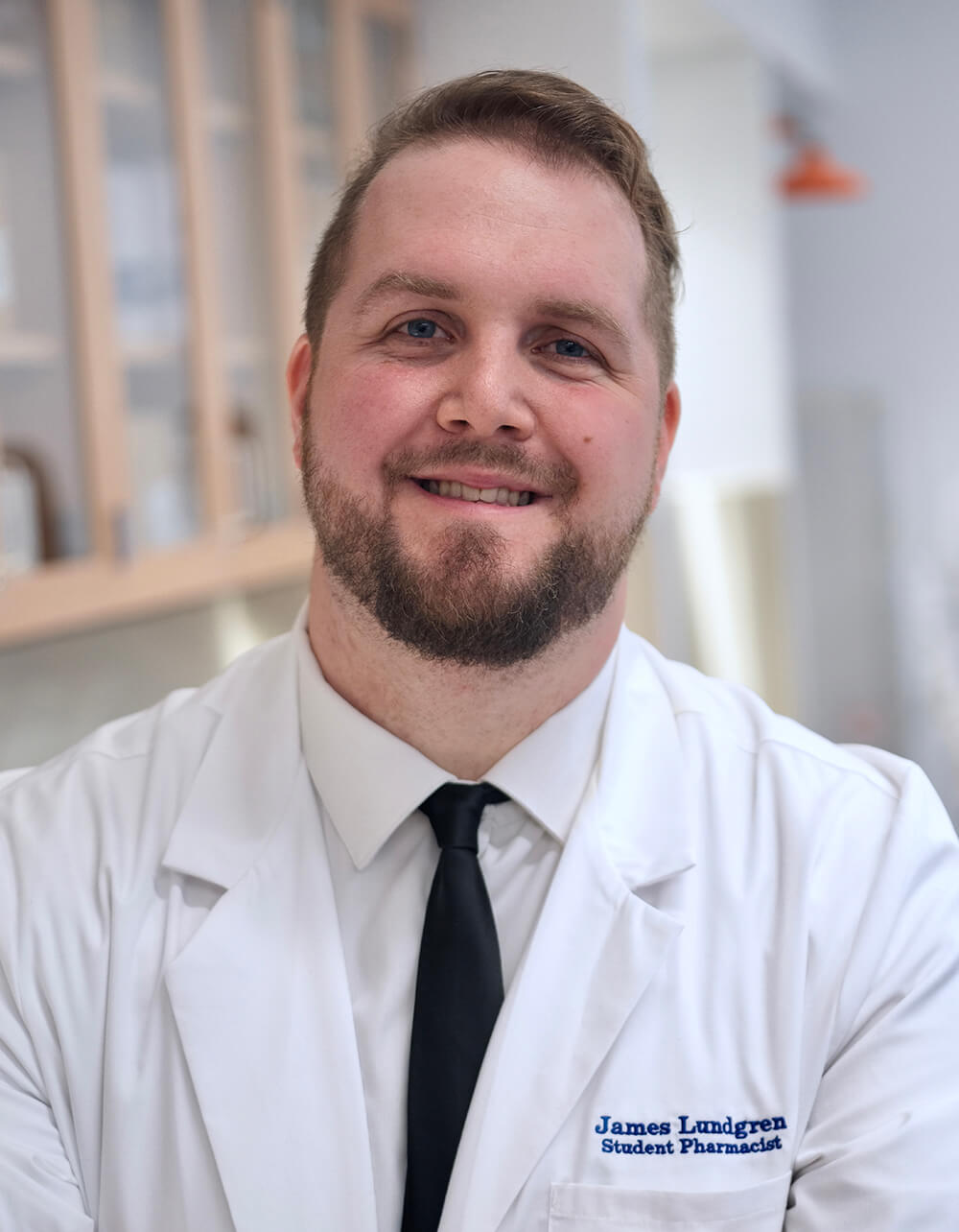 James Lundgren in pharmacy lab, wearing white coat